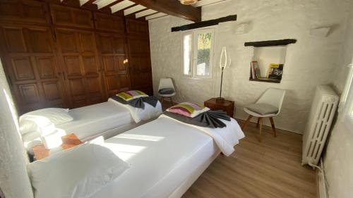 - une chambre avec 2 lits et une chaise dans l'établissement Villa a 2mn de la plage, à Saint-Georges-de-Didonne