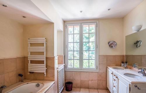 a bathroom with two sinks and a tub and a window at Villa la Malpagne, 400m2 les pieds dans l'eau in Rayol-Canadel-sur-Mer