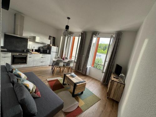 een woonkamer met een bank en een tafel bij Appartement Le Madargue idéalement placé in Châtel-Guyon