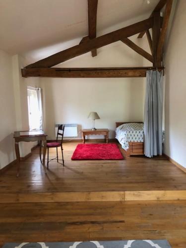 een slaapkamer met een bed en een tafel met een rood tapijt bij chateau de Thegra le Phenix in Balma