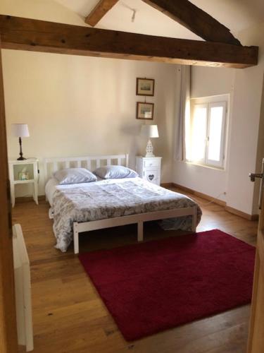 een slaapkamer met een bed en een rood tapijt bij chateau de Thegra le Phenix in Balma