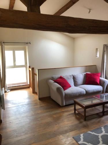 een woonkamer met een bank met twee rode kussens bij chateau de Thegra le Phenix in Balma
