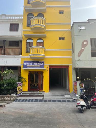 a yellow building with a sign on it at MARTINES RESIDENCY in Puducherry