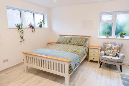 sypialnia z łóżkiem, krzesłem i oknami w obiekcie Soho House in Bordon w mieście Bordon