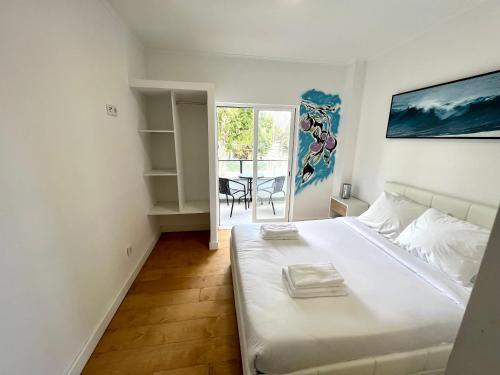 a bedroom with a large white bed and a table at Oeiras Beach guest house in Oeiras