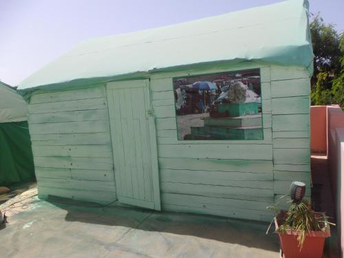 a small green shed with a window in it at Auberge Triskell in Nouakchott