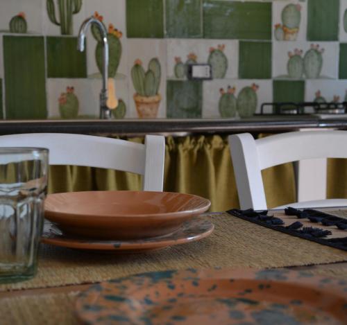 ficodindia Suite & Apartments في سانتو ستيفانو دي كاماسترا: طاولة خشبية مع صحن وكوب ماء