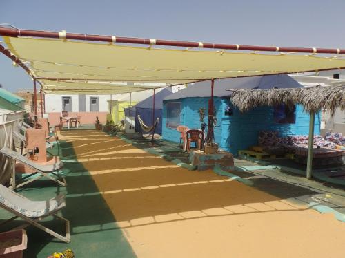 a patio with a blue building with a yellow roof at Auberge Triskell in Nouakchott