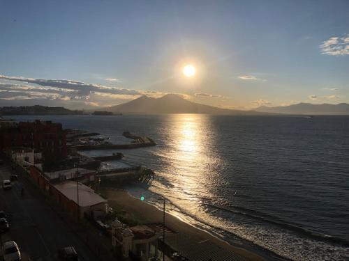 a sunset over a body of water with a city at B&B Vista Mare in Naples