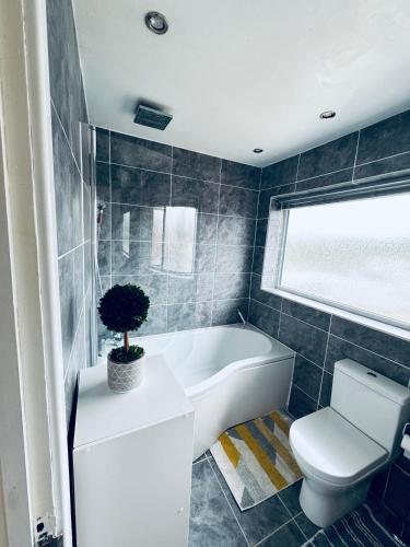 a bathroom with a tub and a toilet and a sink at Family Room close in Bristol