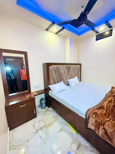 two beds in a room with a blue ceiling at KRISHNA PALACE in Ujjain