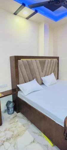 2 camas en una habitación con techo azul en KRISHNA PALACE, en Ujjain