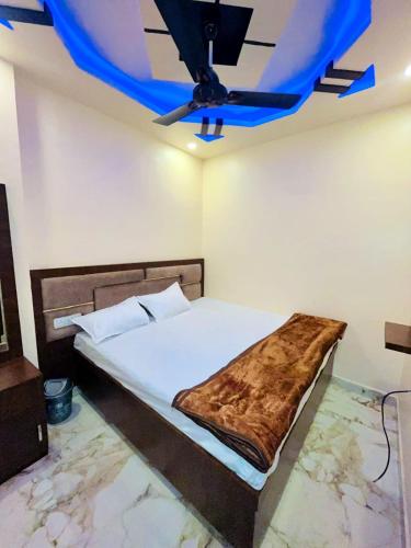 - une chambre avec un lit et un plafond bleu dans l'établissement KRISHNA PALACE, à Ujjain