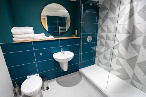 W łazience znajduje się toaleta, umywalka i lustro. w obiekcie The Lake House w Liverpoolu