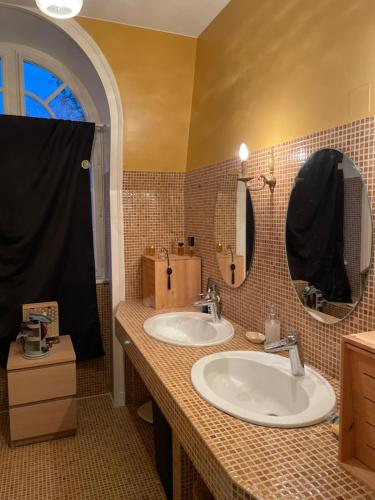 a bathroom with two sinks and two mirrors at Le Bois Perrin in Joinville