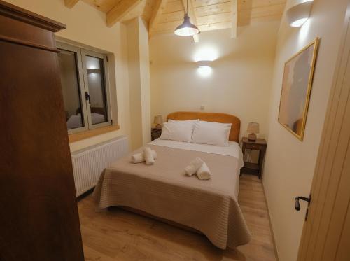 a bedroom with a bed with two towels on it at AROANIA suites in Zarouchla