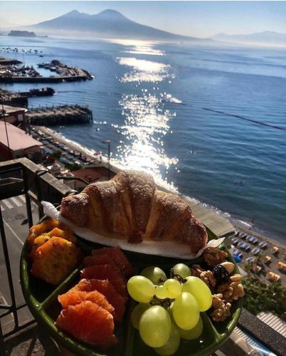 a plate of food on a table next to the ocean at B&B Vista Mare in Naples