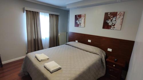 1 dormitorio con 1 cama con 2 toallas en Laguna Azul en Río Gallegos