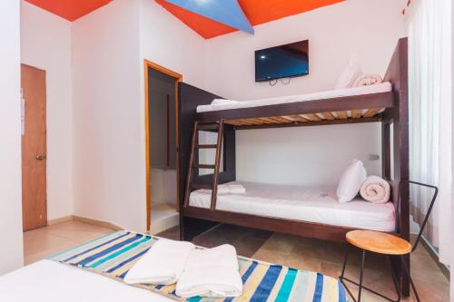 a room with two bunk beds and a tv at Hotel Guatatur in Guatapé