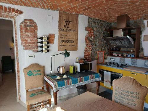 eine Küche mit einem Herd und einer Theke mit einem Tisch in der Unterkunft Dimora Rosso 27 in Fiano