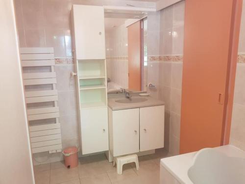 une salle de bain avec un lavabo et un miroir dans l'établissement Maison chaleureuse, magnifique vue mer, à Ploubazlanec