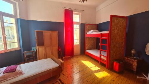 1 dormitorio con 2 literas y cortinas rojas en Doukas Hostel Room, en Heraclión