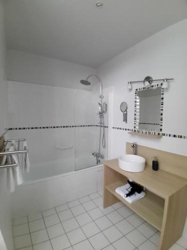 Un baño con lavabo, ducha y bañera. en Hotel Helios - Golf, en Salies-de-Béarn
