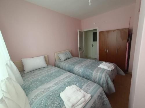 two beds in a small room with pink walls at Apart in Istanbul