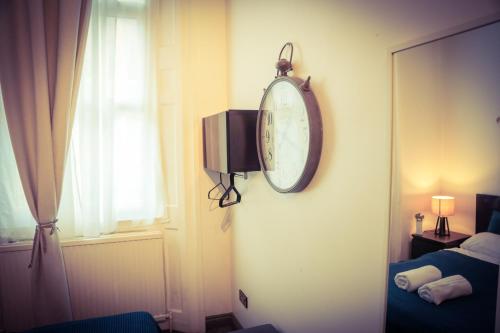 a room with a clock on the wall and a window at Warren Apartment in London