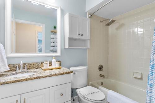 a bathroom with a toilet and a sink and a tub at Beautiful Tropical Home with Private Heated and Chilled Pool in Kissimmee