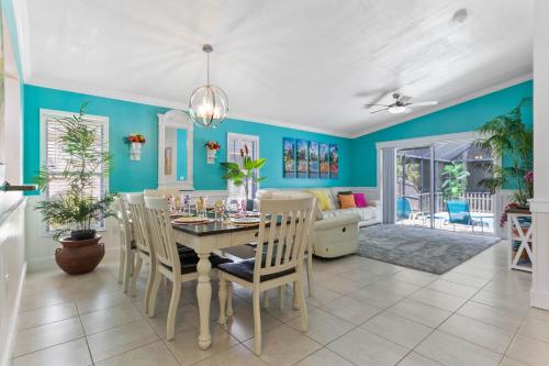 a dining room with blue walls and a table with chairs at Beautiful Tropical Home with Private Heated and Chilled Pool in Kissimmee