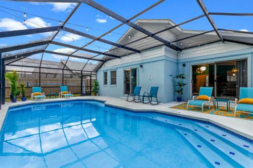 a swimming pool with a pergola and chairs in a house at Beautiful Tropical Home with Private Heated and Chilled Pool in Kissimmee