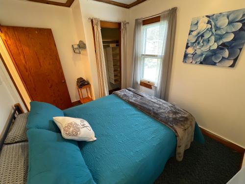 a bedroom with a blue bed and a couch at Quite Cozy Wooded Hideaway in Livingston Manor