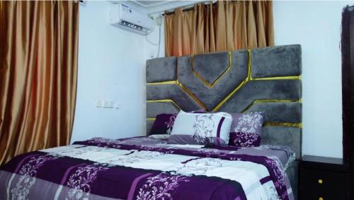 Schlafzimmer mit einem Bett mit Kopfteil in der Unterkunft Logan Point Apartment in Benin-Stadt