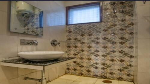 ein Bad mit einem Waschbecken und einer Dusche in der Unterkunft Hotel Grand in Zirakpur