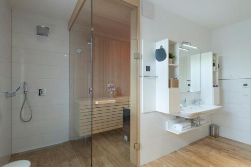 y baño con ducha, lavabo y espejo. en moderne Ferienwohnung mit eigener Sauna und Balkon - Villa Pauline FeWo 06, en Göhren