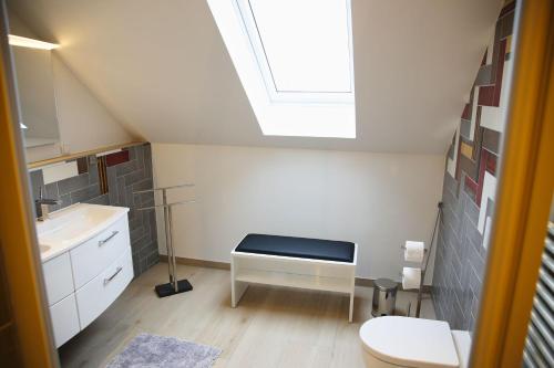 a bathroom with a sink and a toilet and a skylight at modernes Ferienhaus mit Kamin, Garten und eigener Sauna - Ferienhaus Meerfreude in Vaschvitz