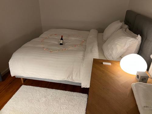 Una cama con una botella de vino encima. en Unik BnB midt i byen - mad event og bilopladning, en Herning