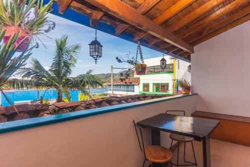 una mesa en un balcón con vistas al océano en Hotel Guatatur en Guatapé