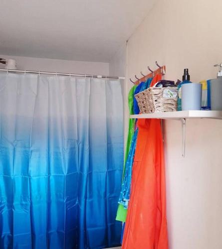 a bathroom with a shower curtain and a shelf with umbrellas at Casa Mamá Vicky - Valle del Colca in Coporaque