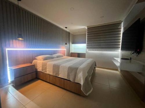 a bedroom with a large bed with a light on it at Feel at home in Sabaneta