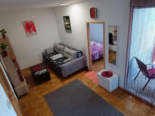 een woonkamer met een bank en een spiegel bij Apartman Ante in Gospić