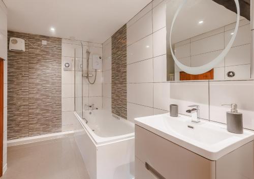 ein weißes Badezimmer mit einem Waschbecken und einem Spiegel in der Unterkunft Granary Cottage in Swimbridge