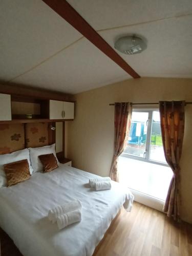 a bedroom with a large white bed with a window at Holiday Cottage Seaside in Knokke-Heist