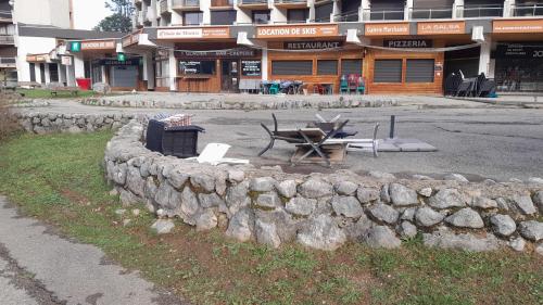 a stone wall with a picnic table in front of a building at Joli studio au pied des pistes in Villard-de-Lans
