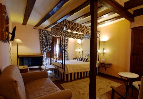 ein Schlafzimmer mit einem Himmelbett und ein Wohnzimmer in der Unterkunft Casa Rural de Legarda in Briñas