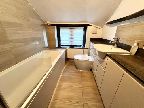 a bathroom with a tub and a toilet and a sink at Reads Cottage in Waterlooville