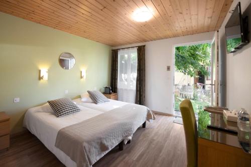 a bedroom with two beds and a large window at Motel-Restaurant 13 Etoiles in Sierre