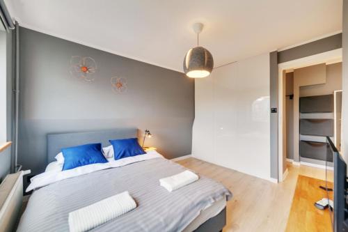 een slaapkamer met een groot bed met blauwe kussens bij Dream Loft Motlava River in Gdańsk