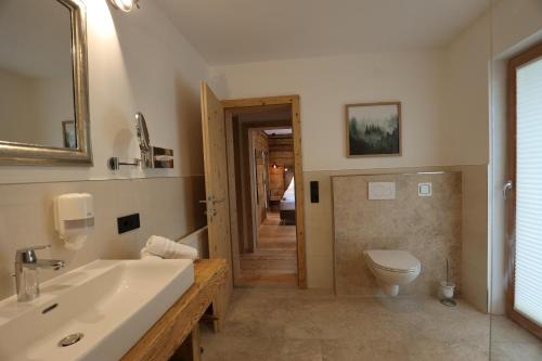 a bathroom with a sink and a toilet and a mirror at Pension & Appartements Ronacherhof in Bad Kleinkirchheim